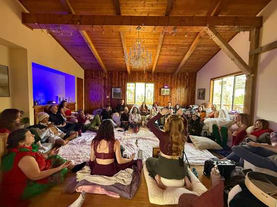 A facilitator teaching a seated circle in the great room