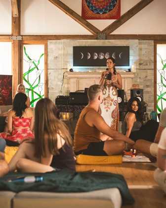 A facilitator speaking to a seated circle in the great room
